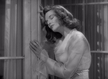 Movie still from “The Philadelphia Story” (1940), directed by George Cukor – A black - and - white photo of a woman praying; Medium shot, High angle