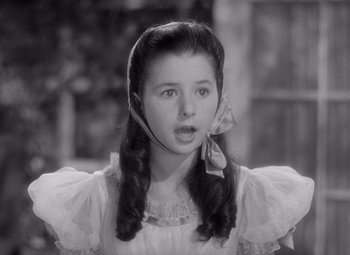 Movie still from “The Philadelphia Story” (1940), directed by George Cukor – A young girl in a white dress with long black hair; Close Up shot, High angle
