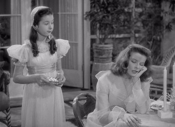 Movie still from “The Philadelphia Story” (1940), directed by George Cukor – Two young girls are sitting at a dining room table; Medium shot, High angle