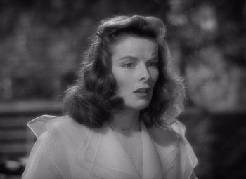 Movie still from “The Philadelphia Story” (1940), directed by George Cukor – A black - and - white photo of a woman in a white dress; Close Up shot, Low angle