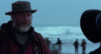 Movie still from “The Piano” (1993), directed by Jane Campion – An old man with a beard wearing a straw hat; Close Up shot, Over the shoulder angle