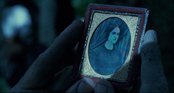 Movie still from “The Piano” (1993), directed by Jane Campion – A person holding a picture of a woman in a frame; Extreme Close Up shot, Over the shoulder angle
