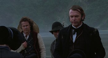 Movie still from “The Piano” (1993), directed by Jane Campion – A group of men standing next to each other on a field; Medium shot, Over the shoulder angle
