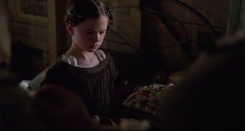 Movie still from “The Piano” (1993), directed by Jane Campion – A young girl is looking down at a pillow; Close Up shot, Over the shoulder angle
