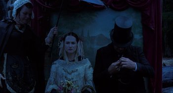 Movie still from “The Piano” (1993), directed by Jane Campion – A woman in a white dress holding a blue umbrella; Medium shot, Low angle