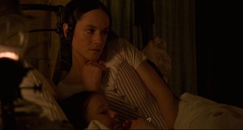 Movie still from “The Piano” (1993), directed by Jane Campion – A woman and a child laying in a bed together; Close Up shot, High angle