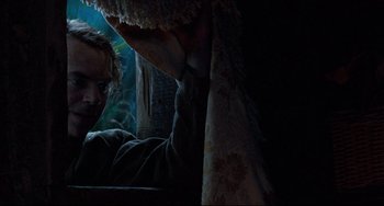 Movie still from “The Piano” (1993), directed by Jane Campion – A man in a dark room looking at something on the ground; Medium shot, Low angle