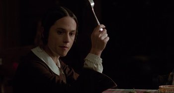 Movie still from “The Piano” (1993), directed by Jane Campion – A woman holding a fork in a dark room; Close Up shot, High angle