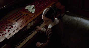 Movie still from “The Piano” (1993), directed by Jane Campion – A woman playing the piano in a dark room; Medium shot, High angle