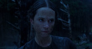 Movie still from “The Piano” (1993), directed by Jane Campion – A woman in a black shirt is standing in the rain; Close Up shot, Low angle