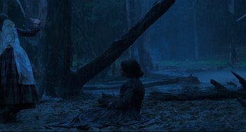 Movie still from “The Piano” (1993), directed by Jane Campion – A woman sitting on the ground in the woods; Wide shot, High angle