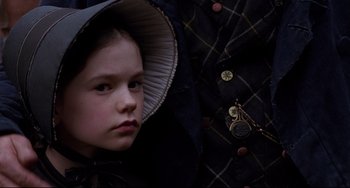Movie still from “The Piano” (1993), directed by Jane Campion – A little girl wearing a hat and a coat; Close Up shot, Over the shoulder angle
