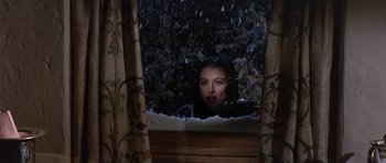 Movie still from “The Pink Panther” (1963), directed by Blake Edwards – A woman looking out of a window at the snow; Medium shot, Over the shoulder angle