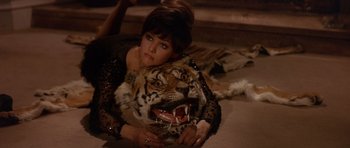 Movie still from “The Pink Panther” (1963), directed by Blake Edwards – A woman laying on the ground with a tiger head on her chest; Medium shot, High angle
