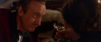 Movie still from “The Pink Panther” (1963), directed by Blake Edwards – A man and a woman sitting at a table with a glass of wine; Close Up shot, Over the shoulder angle