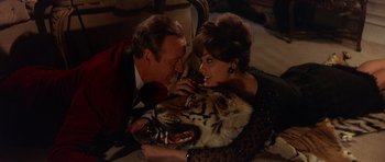 Movie still from “The Pink Panther” (1963), directed by Blake Edwards – A man and a woman laying on the ground with a tiger; Medium shot, High angle