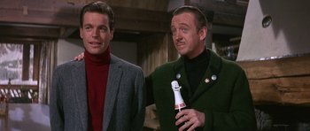 Movie still from “The Pink Panther” (1963), directed by Blake Edwards – A man holding a bottle and another man standing next to him; Medium shot, Low angle