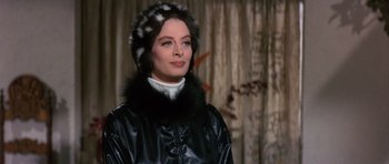 Movie still from “The Pink Panther” (1963), directed by Blake Edwards – A woman wearing a black leather jacket and a fur hat; Close Up shot, Over the shoulder angle