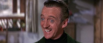 Movie still from “The Pink Panther” (1963), directed by Blake Edwards – An older man with blue eyes smiling for the camera; Close Up shot, High angle