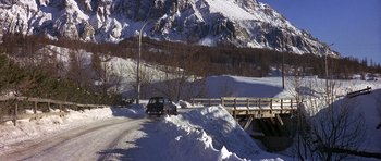 Movie still from “The Pink Panther” (1963), directed by Blake Edwards – A car driving down a snowy road near a bridge; Extreme Wide shot, High angle