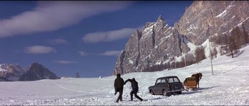 Movie still from “The Pink Panther” (1963), directed by Blake Edwards – Two people are playing in the snow near a car; Extreme Wide shot, Low angle