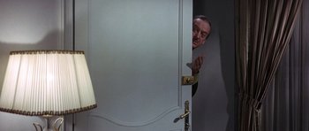 Movie still from “The Pink Panther” (1963), directed by Blake Edwards – A man peeks out from behind a door; Medium shot, Over the shoulder angle