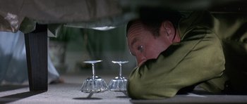 Movie still from “The Pink Panther” (1963), directed by Blake Edwards – A man leaning on the ground with two wine glasses; Close Up shot, Overhead angle