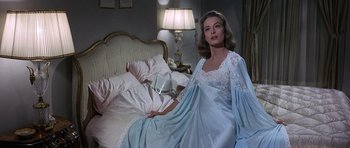 Movie still from “The Pink Panther” (1963), directed by Blake Edwards – A woman sitting on a bed wearing a nightgown; Medium shot, Over the shoulder angle