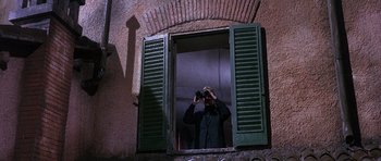 Movie still from “The Pink Panther” (1963), directed by Blake Edwards – A man taking a picture of himself through a window; Medium shot, Low angle