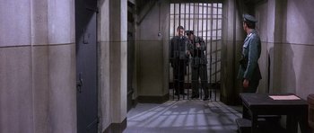 Movie still from “The Pink Panther” (1963), directed by Blake Edwards – Two men standing in front of a jail cell; Wide shot, High angle