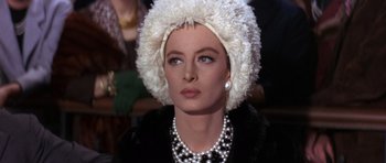 Movie still from “The Pink Panther” (1963), directed by Blake Edwards – A person wearing pearls and a fur hat; Close Up shot, Over the shoulder angle
