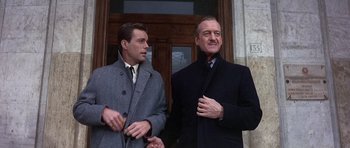 Movie still from “The Pink Panther” (1963), directed by Blake Edwards – Two men standing next to each other outside a building; Medium shot, Low angle