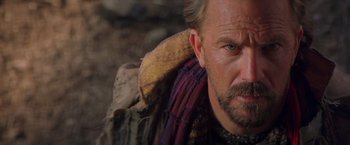 Movie still from “The Postman” (1997), directed by Kevin Costner – A man with a beard; Close Up shot, Over the shoulder angle