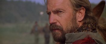 Movie still from “The Postman” (1997), directed by Kevin Costner – A person with a beard; Close Up shot, Over the shoulder angle