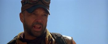 Movie still from “The Postman” (1997), directed by Kevin Costner – A person wearing a hat and goggles; Close Up shot, Over the shoulder angle
