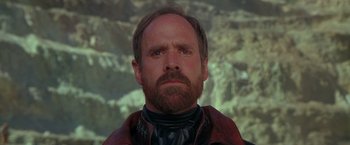 Movie still from “The Postman” (1997), directed by Kevin Costner – A man with a goatee is looking at the camera; Close Up shot, Low angle