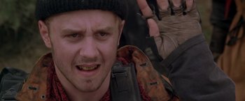 Movie still from “The Postman” (1997), directed by Kevin Costner – A person with a backpack; Close Up shot, Over the shoulder angle