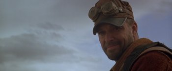 Movie still from “The Postman” (1997), directed by Kevin Costner – A person wearing a hat and goggles; Close Up shot, Low angle