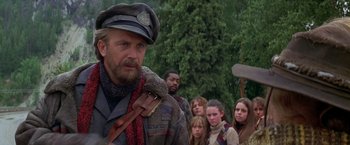 Movie still from “The Postman” (1997), directed by Kevin Costner – A group of people standing in front of each other; Medium shot, Over the shoulder angle