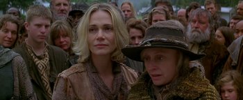 Movie still from “The Postman” (1997), directed by Kevin Costner – A group of people standing next to each other in a field; Close Up shot, Over the shoulder angle