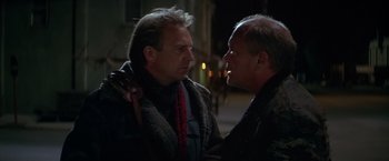 Movie still from “The Postman” (1997), directed by Kevin Costner – Two men standing next to each other on the street; Close Up shot, Low angle