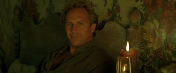 Movie still from “The Postman” (1997), directed by Kevin Costner – A person sitting in a chair; Close Up shot, Low angle