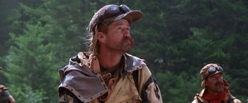 Movie still from “The Postman” (1997), directed by Kevin Costner – A man with a beard wearing a hat and a jacket; Close Up shot, Low angle