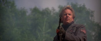 Movie still from “The Postman” (1997), directed by Kevin Costner – A man holding a gun in his hand; Close Up shot, Low angle