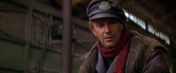 Movie still from “The Postman” (1997), directed by Kevin Costner – A man wearing a hat and a scarf; Close Up shot, Low angle