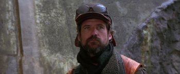 Movie still from “The Postman” (1997), directed by Kevin Costner – A man with a goatee wearing a hat and goggles; Close Up shot, Low angle