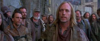 Movie still from “The Postman” (1997), directed by Kevin Costner – A group of men standing next to each other; Close Up shot, Over the shoulder angle