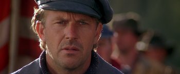 Movie still from “The Postman” (1997), directed by Kevin Costner – A person wearing a hat; Close Up shot, Over the shoulder angle