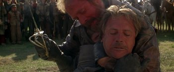 Movie still from “The Postman” (1997), directed by Kevin Costner – Two men are wrestling each other in a field; Close Up shot, Over the shoulder angle