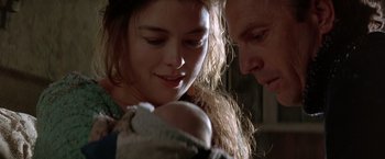 Movie still from “The Postman” (1997), directed by Kevin Costner – A man and a woman looking at a baby; Close Up shot, Low angle
